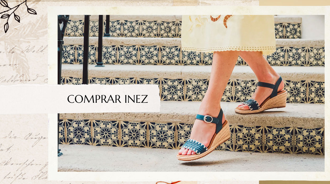 Mujer bajando unas escaleras con la sandalia Inez en azul. Compra la Inez.