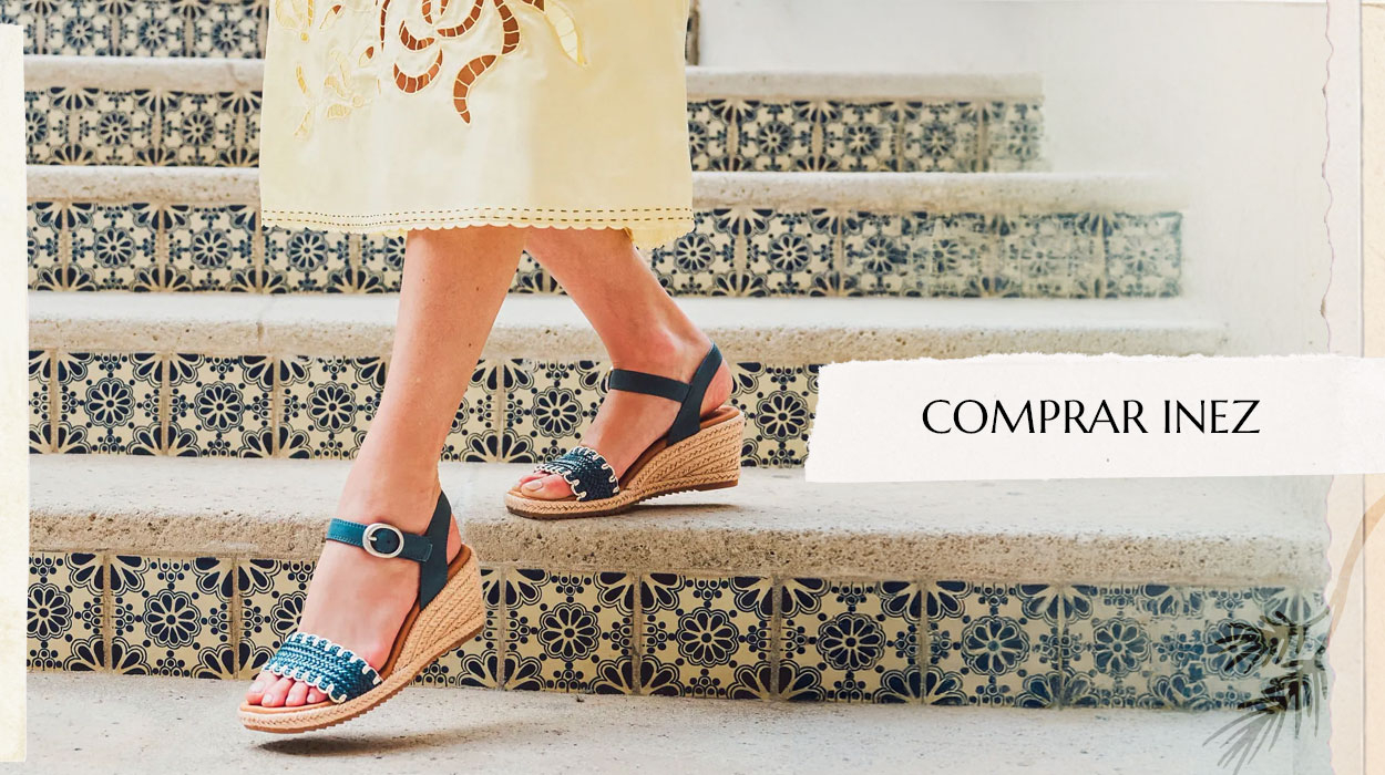 Mujer bajando unas escaleras, llevando la sandalia Inez en azul. Comprar Inez.
